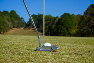 Golf ball and golf club in beautiful golf course at sunset background.