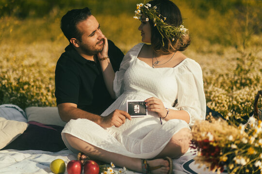 Pregnant woman and husband having picnic.