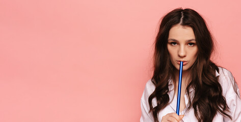 Young, beautiful girl smokes a hookah, shisha. It produces smoke from his mouth. The pleasure of...