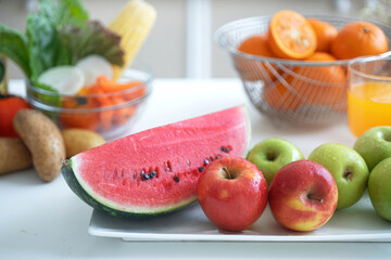 Various kind of fresh fruit on white table, melon, apple green apple, orange, closeup