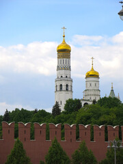 Fototapeta na wymiar The Kremlin wall made of red brick and the Church-Bell Tower of Ivan the Great as part of the architectural ensemble of the Cathedral Square of the Moscow Kremlin