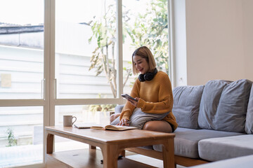 Attractive Asian woman resting comfortable living room and using mobile phone, Relax, Sofa, Lifestyle