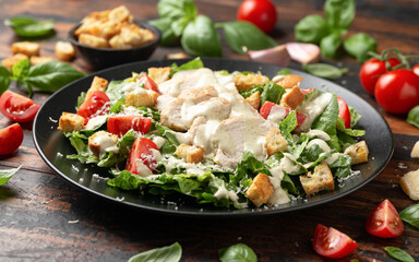 A delicious chicken caesar salad with parmesan cheese, tomatoes, croutons and dressing