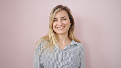 Obraz premium Young blonde woman smiling confident standing over isolated pink background