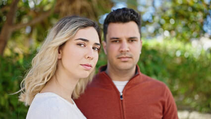 Obraz premium Man and woman couple standing together with relaxed expression at park