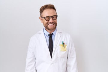Middle age doctor man with beard wearing white coat winking looking at the camera with sexy...