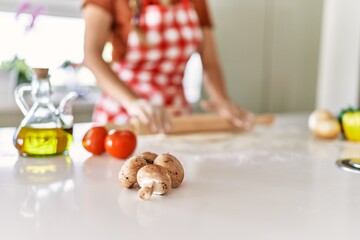 Obraz na płótnie Canvas Young beautiful hispanic woman kneading dough pizza at the kitchen