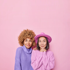 Vertical shot of two thoughtful women have dreamy expressions concentrated above dressed in casual...