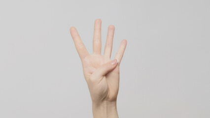 Hand gesture. Four number. Woman showing trio fingers up on light gray background.