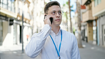 Young hispanic man talking on smartphone with relaxed expression at street