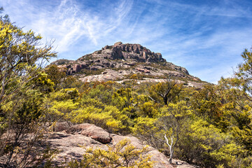 View of the Hazards, a mountain range at Wineglass Bay, Freycinet National Park, Tasmania. Rocky outcrop surrounded by eucalyptus forest. Summer sky background.