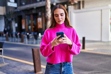 Fototapeta premium Young woman using smartphone at street