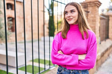 Young woman smiling confident standing with arms crossed gesture at street