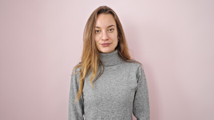 Fototapeta premium Young caucasian woman standing with serious expression over isolated pink background