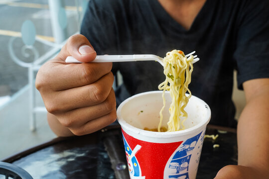 instant noodles, noodle soup in a cup, boys hand feeding ready to eat noodles
