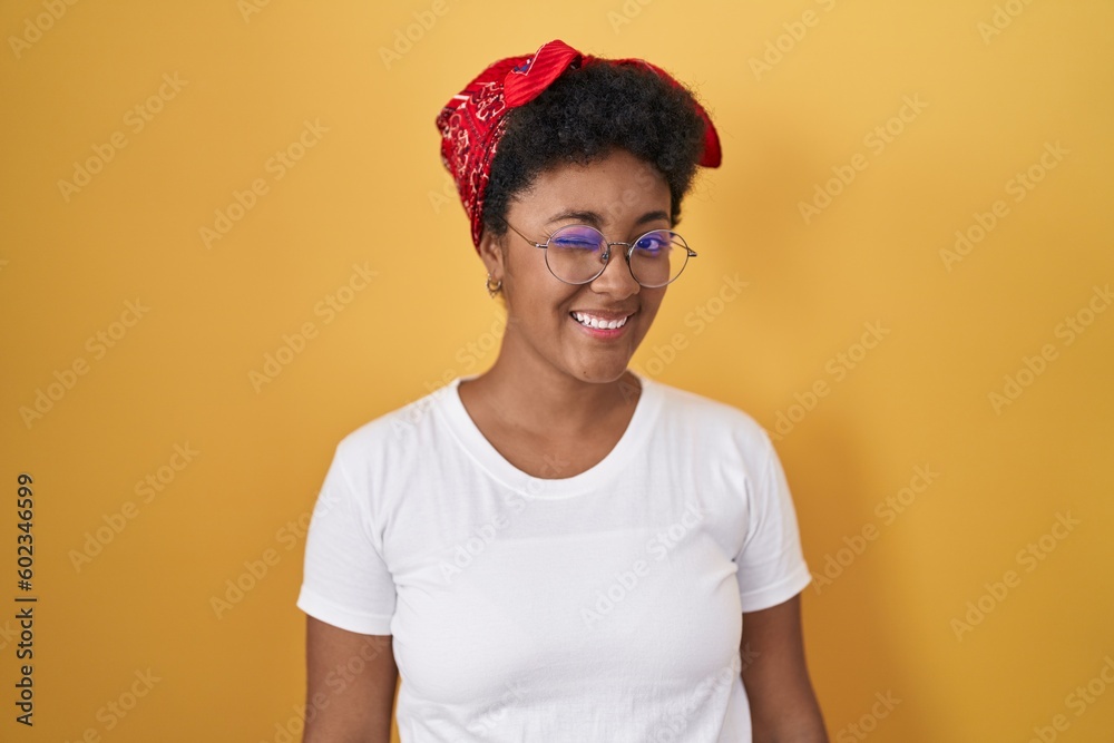 Sticker young african american woman standing over yellow background winking looking at the camera with sexy