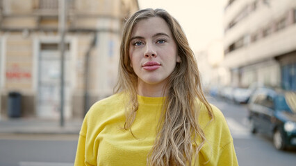 Fototapeta premium Young blonde woman standing with relaxed expression at street