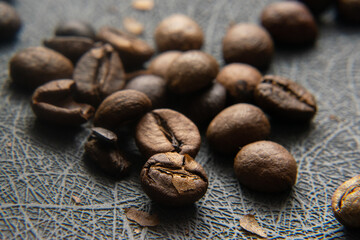 The Fresh Aroma of Roasted Coffee Beans. The aroma of freshly roasted coffee beans fills the air, emanating from the warm brown beans scattered on a table.