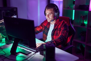 Young caucasian man streamer playing video game using computer at gaming room