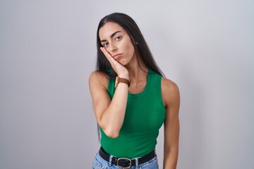 Young woman standing over isolated background thinking looking tired and bored with depression...