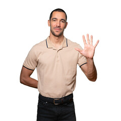 Naklejka premium Young man making a number five gesture