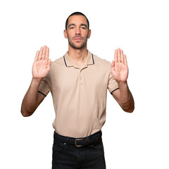 Happy young man making a gesture of stop with his palm