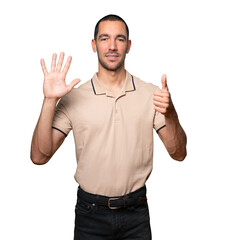 Naklejka premium Happy young man doing a number six gesture with his hands