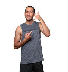 Hesitant young man making a gesture of calling with the hand