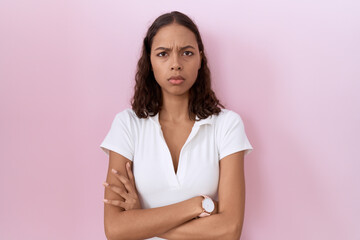 Young hispanic woman wearing casual white t shirt skeptic and nervous, disapproving expression on face with crossed arms. negative person.