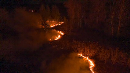 Night fire in the forest with fire and smoke.Epic aerial photo of a smoking wild flame.A...
