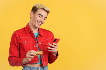Happy gay man using the mobile phone to shopping online