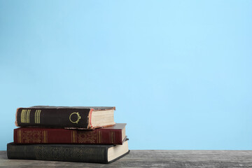 Stack of old books on wooden table, space for text