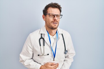 Young hispanic man wearing doctor uniform and stethoscope with hand on stomach because indigestion, painful illness feeling unwell. ache concept.