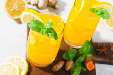 Ginger and Turmeric Lemonade, Healthy Refreshing Beverage with Turmeric Root and Spices, Jamu Juice, Immunity Booster Drink on Bright Background