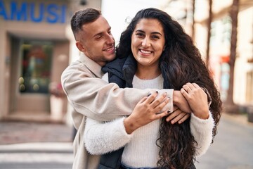 Man and woman couple hugging each other standing at street