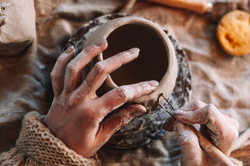 Female sculptor making clay mug in a home workshop,hands close-up.Small business,entrepreneurship,hobby, leisure concept.