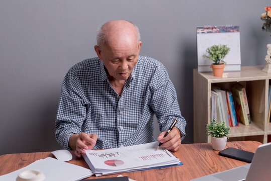 Asian senior businessman looking at marketing graph business report