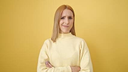 Fototapeta premium Young blonde woman standing with relaxed expression and arms crossed gesture over isolated yellow background