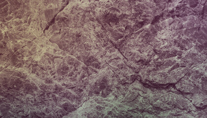 A close up of a stone with a purple, green and yellow background