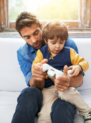 Gaming, father and son on a sofa, video game and loving at home, quality time and relax in the...
