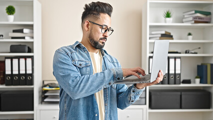 Fototapeta premium Young latin man business worker using laptop working at office