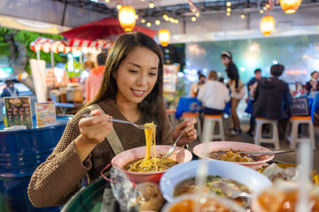 Woman enjoy her Thai noodle at Thai restaurant