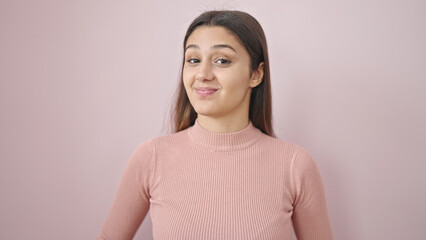 Fototapeta premium Young beautiful hispanic woman smiling confident standing over isolated pink background