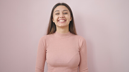Fototapeta premium Young beautiful hispanic woman smiling confident standing over isolated pink background