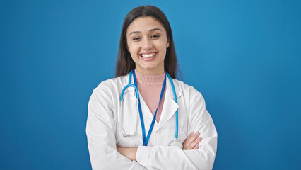 Young beautiful hispanic woman doctor standing with arms crossed gesture saying yes with head over...