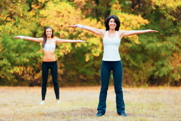 Women, arm stretching and portrait in a outdoor park for yoga and fitness. Health, wellness and arms exercise of female friends in nature on grass feeling happy with smile from body and sport