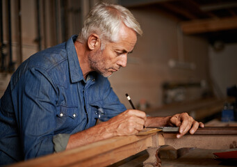 Carpentry, focus and man with pencil, table and creative work at furniture manufacturing workshop....