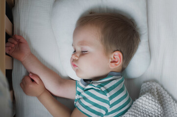 Toddler boy sleeping close-up on bed. Health care concept