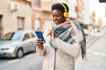 African american woman smiling confident listening to music at street