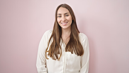 Fototapeta premium Young beautiful hispanic woman smiling confident standing over isolated pink background